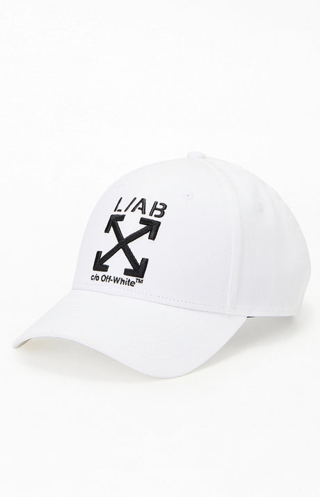A white baseball cap featuring the black embroidered 'L/AB' logo and the Off-White arrow cross graphic on the front, with 'cs Off-White' printed below, set against a plain white background.