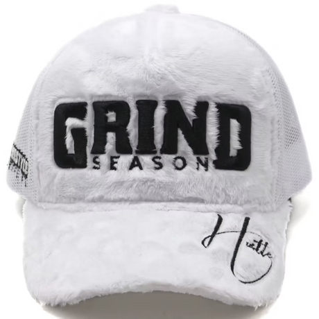 A white fuzzy trucker hat with black embroidered text reading 'GRIND SEASON' on the front and a black script logo on the brim, shown against a plain white background.